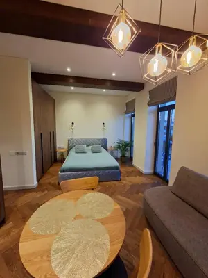 a living room with a bed and a table at Viktor Nemuno house in Kaunas