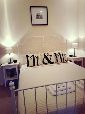 a bedroom with a white bed with pillows on it at Country Stop Room and Shower in Pikeliškės