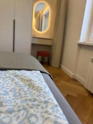 a bedroom with a bed with a mirror and a chair at Exclusive 2 Bedroom Apartment Trendy City Center, Large Terrace & Free Parking in Vilnius