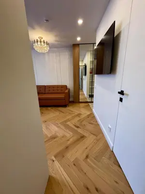 a living room with a couch and a chandelier at Exclusive 2 Bedroom Apartment Trendy City Center, Large Terrace & Free Parking in Vilnius