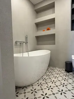 a white tub in a bathroom with a tiled floor at Exclusive 2 Bedroom Apartment Trendy City Center, Large Terrace & Free Parking in Vilnius