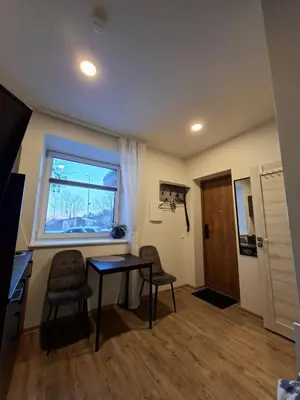 a room with a desk and two chairs and a window at Uzupio justo namai in Kaunas