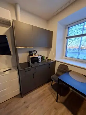 a small kitchen with a microwave and a table at Uzupio justo namai in Kaunas