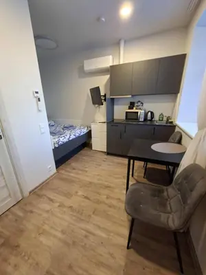 a small room with a table and a bedroom at Uzupio justo namai in Kaunas