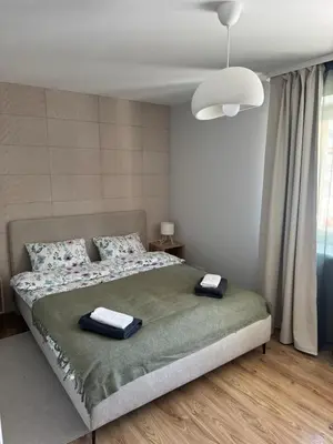 a bedroom with a bed with two towels on it at Urban Nest Čiurlionio Apartment City Center in Druskininkai