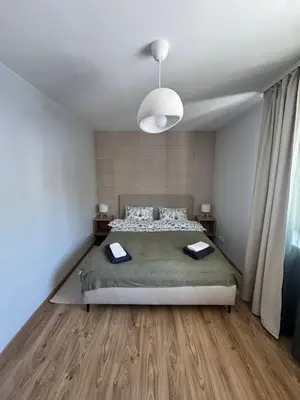 a bedroom with a large bed and a ceiling at Urban Nest Čiurlionio Apartment City Center in Druskininkai