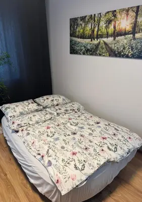 a bed in a room with a painting on the wall at Urban Nest Čiurlionio Apartment City Center in Druskininkai
