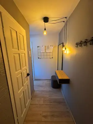 a hallway with a door and a bench in a room at Urban Nest Čiurlionio Apartment City Center in Druskininkai