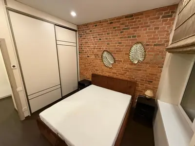 a room with a bed and a brick wall at Kęstučio 66 apartamentai in Kaunas