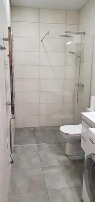 a bathroom with a glass shower and a toilet at Kęstučio 66 apartamentai in Kaunas