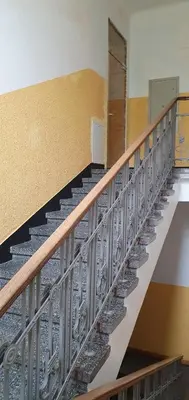 a metal staircase in a room with a wall at Kęstučio 66 apartamentai in Kaunas