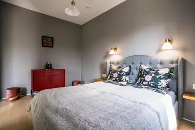 a bedroom with a blue bed and a red cabinet at River apartamentai in Pakopi