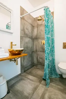 a bathroom with a shower with a blue shower curtain at River apartamentai in Pakopi