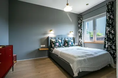 a bedroom with a bed with blue walls and a window at River apartamentai in Pakopi