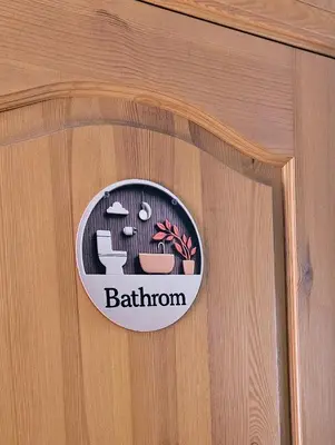 a wooden door with a bathroom sign on it at Skodupės švenčių ir poilsio namai in Pakopi