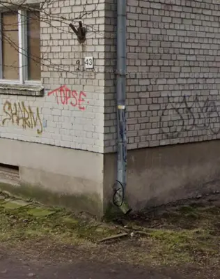 a brick building with graffiti on the side of it at The Calm Place in Kaunas