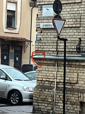 a yield sign on the side of a brick building at The Calm Place in Kaunas