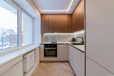 a kitchen with white cabinets and a window at Sandal Apartments in Šiauliai