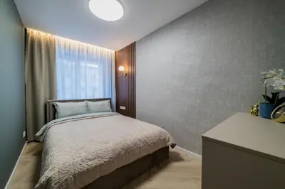 a small bedroom with a bed and a window at Sandal Apartments in Šiauliai