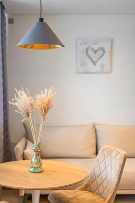 a table with a vase of flowers and a lamp at Fancy Pramonės Stay #1 By Polo Apartments in Kaunas