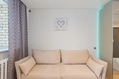a couch in a living room with a heart picture on the wall at Fancy Pramonės Stay #1 By Polo Apartments in Kaunas