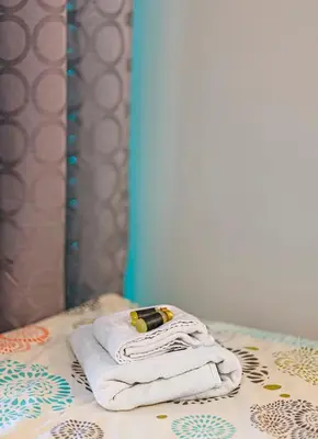 a stack of towels on a bed in front of a mirror at Fancy Pramonės Stay #1 By Polo Apartments in Kaunas