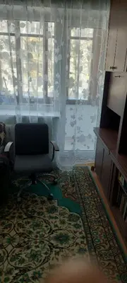 a living room with a chair and a rug at Flat 2 rooms in Panevėžys