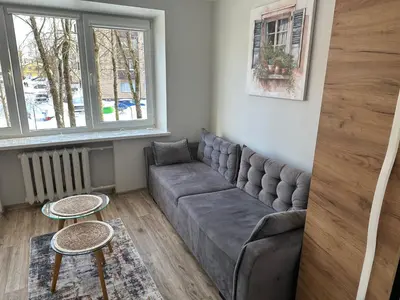 a living room with a couch and two tables at Studio between two stations in Šiauliai