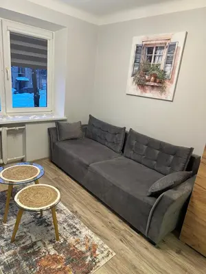 a living room with a couch and two tables at Studio between two stations in Šiauliai