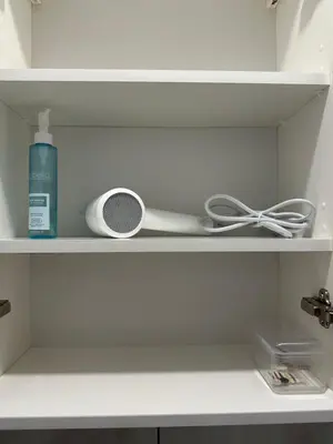 a shelf with a fan and a bottle on it at Studio between two stations in Šiauliai