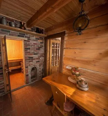a wooden room with a wooden table and a fireplace at Sudervės pirtelė poilsiui gamtoje, Vilnius už 12 km in Sudervė