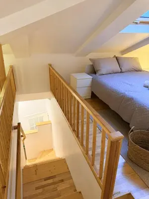 a attic bedroom with a bed and a staircase at Cosy quiet apartment in the city center in Vilnius