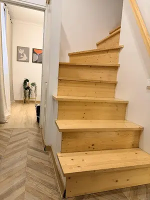 a stairwell in a home with wooden steps at Cosy quiet apartment in the city center in Vilnius