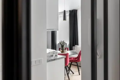 a living room with a table and red chairs at Vilnius Studio Apartment with Free Parking and Self Check In in Vilnius