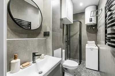 a bathroom with a sink and a mirror and a toilet at Vilnius Studio Apartment with Free Parking and Self Check In in Vilnius