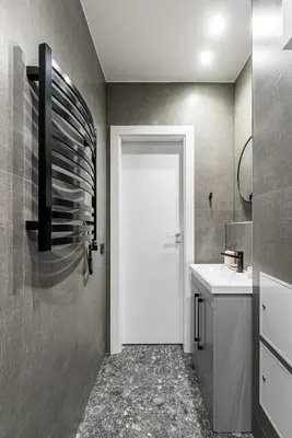 a bathroom with a white door and a sink at Vilnius Studio Apartment with Free Parking and Self Check In in Vilnius