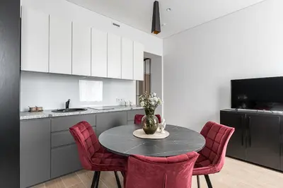 a kitchen with a table and some red chairs at Vilnius Studio Apartment with Free Parking and Self Check In in Vilnius