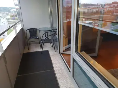 a balcony with a table and chairs in a building at Vilnius Gate Skyline Studio in Vilnius