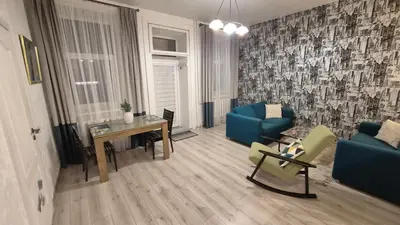 a living room with a blue couch and a table at Plytų Sienos Apartamentai in Kaunas