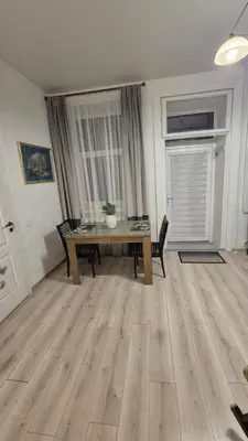 a living room with a wooden table and chairs at Plytų Sienos Apartamentai in Kaunas