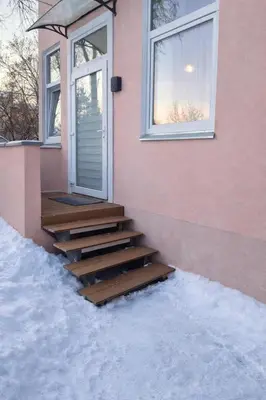 a set of stairs leading to a door on a house at Plytų Sienos Apartamentai in Kaunas