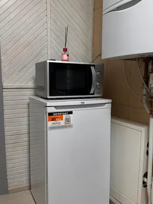 a microwave sitting on top of a refrigerator at Užupio apartamentai Nemokamas parkingas 3 in Vilnius