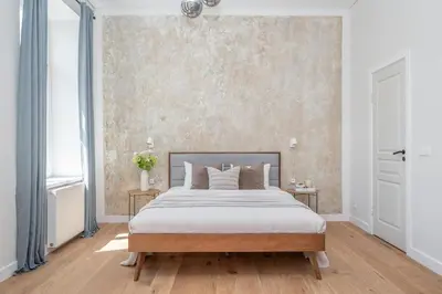 a bedroom with a large bed and a wall at Sunny Garden Street Apartment in Vilnius in Vilnius