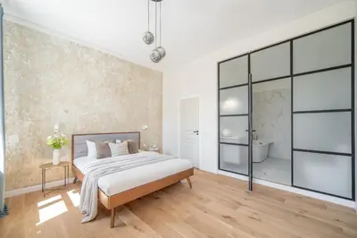 a bedroom with a large bed and a bath tub at Sunny Garden Street Apartment in Vilnius in Vilnius