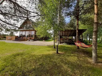 a hammock in a park with a gazebo at Gintarinė rasa in Inkartai
