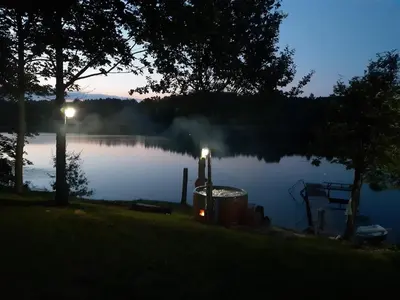 a lake at night with a grill next to it at Gintarinė rasa in Inkartai