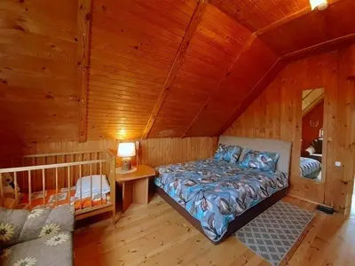a bedroom with a bed in a wooden cabin at Gintarinė rasa in Inkartai