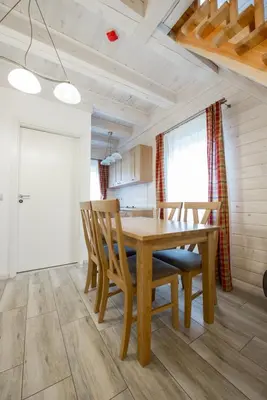 a dining room with a wooden table and chairs at Panemunio sodyba in Birštonas