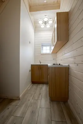 a kitchen with wooden cabinets and a ceiling at Panemunio sodyba in Birštonas