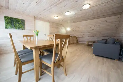 a dining room with a wooden table and chairs at Panemunio sodyba in Birštonas